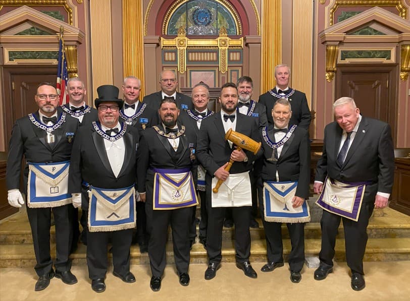 Members of Prospect Lodge in formal Masonic regalia gathered together in the lodge room